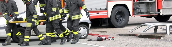 wounded person carried by firefighters on a stretcher