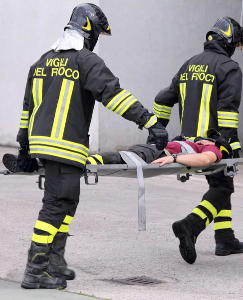 Firefighters carried the injured away on stretchers — Stock Photo, Image