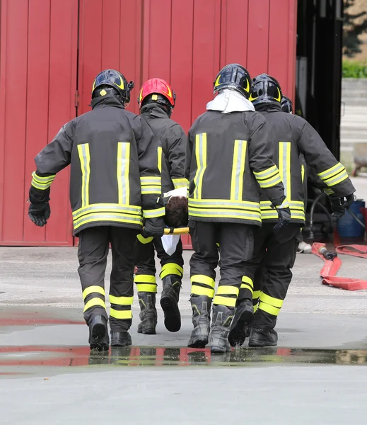 Wounded carried by firefighters on a stretcher — Stock Photo, Image