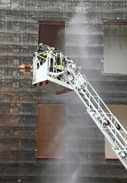 Пожежники в кошику пожежної машини під час тренувань — стокове фото