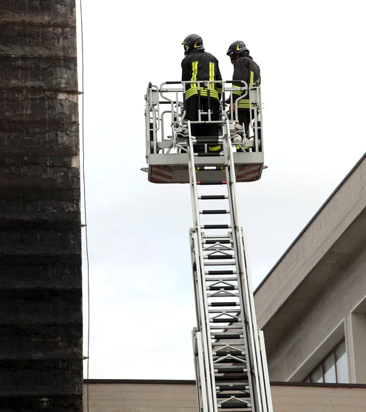 Bomberos en la cesta del camión de bomberos durante la práctica de tra —  Fotos de Stock