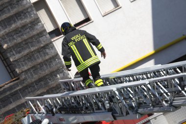 firetrucks sırasında genişletilmiş merdivenin üzerinde yürüyen itfaiyeci 