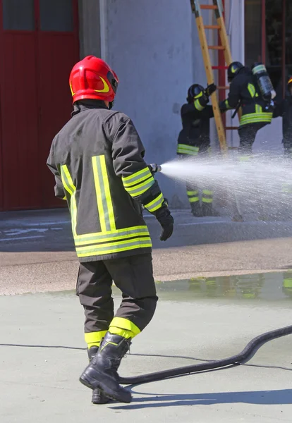 Pompier pulvérise de l'eau avec le combat de lance pendant l'exer — Photo