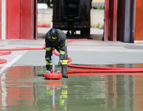 Firefighter positions a powerful fire hydrant during the exercis — Stock Photo, Image