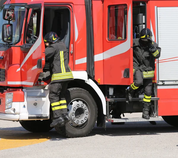 Brandweerlieden in actie springen neer snel van de vrachtwagen — Stockfoto