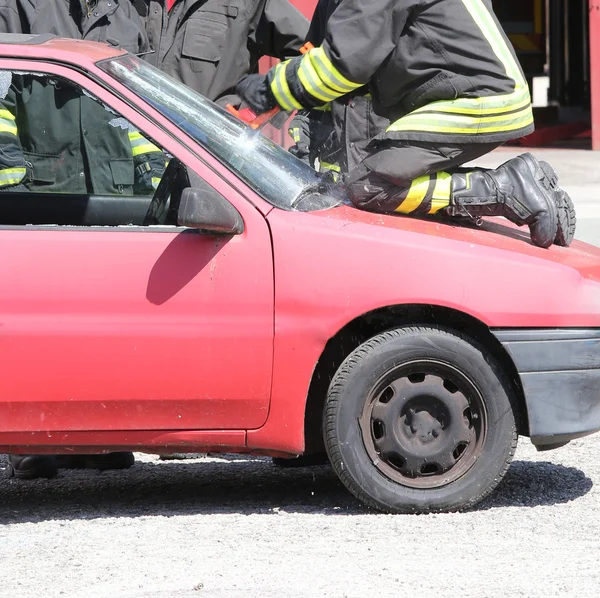 Firefighter cuts the windshield  of car with a special Hacksaw