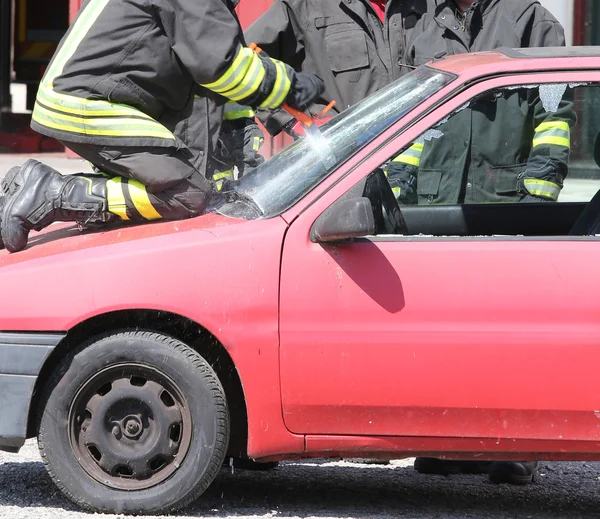 Firefighter cuts the windshield  of car with a special Hacksaw