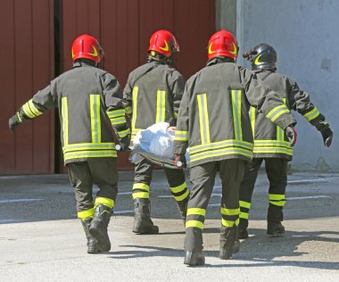 İtalyan itfaiye taşımak bir sedye ile yaralı