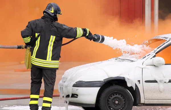 Pompiere spento il fuoco con schiuma combattimento — Foto Stock