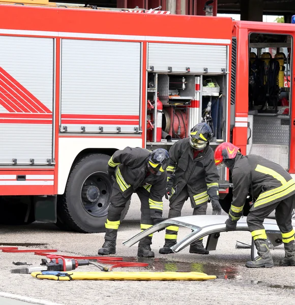 Feuerwehrleute bei einem Verkehrsunfall mit Autoteilen — Stockfoto
