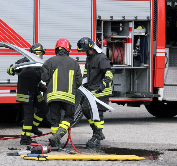 Firefighters during a road accident with car parts — Stock Photo, Image