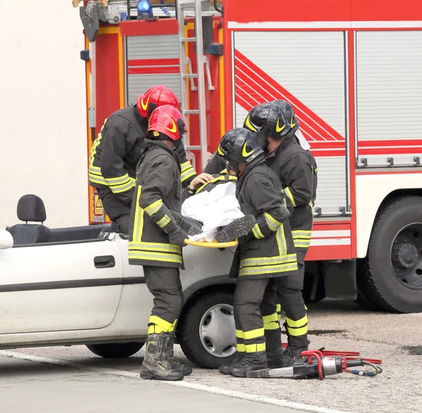 Italian firefighters relieve an injured after car accident — Stock Photo, Image