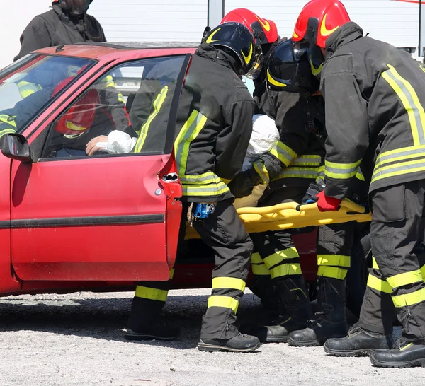 Europejskiej strażacy w akcji i ciągnąć rannych z ca — Zdjęcie stockowe