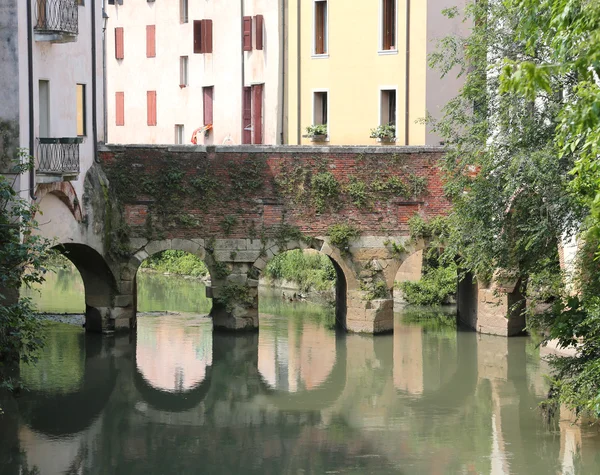 Древний арочный мост через реку в европейском городе — стоковое фото