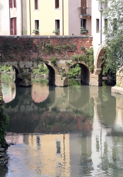 Antico ponte ad arco sul fiume nella città italiana — Foto Stock