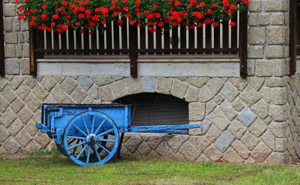 Carrinho de madeira com o gerânio — Fotografia de Stock