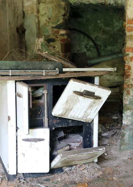 Estufa de leña oxidada en una antigua casa abandonada —  Fotos de Stock