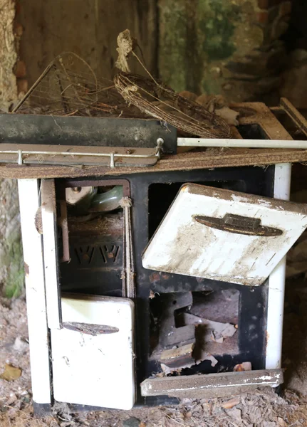 Estufa de leña oxidada en una antigua casa destruida abandonada —  Fotos de Stock