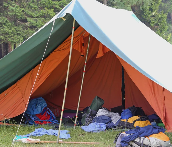 Tenda de menino scout acampamento com mochilas e sacos de dormir espalhados o — Fotografia de Stock