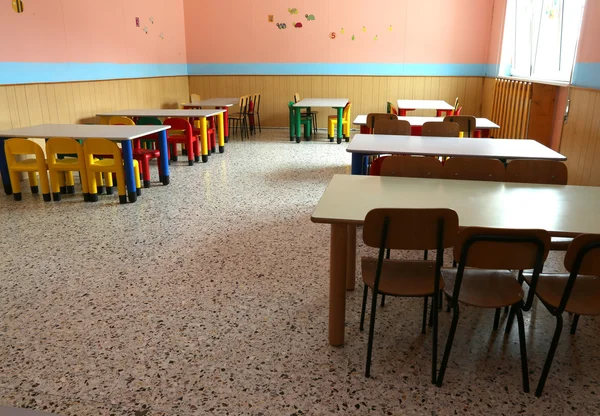 Трапезная детского сада с красочными стульями и обеденными столами — стоковое фото