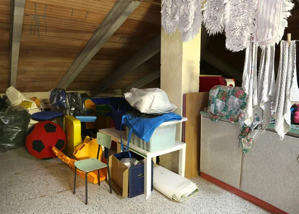 Attic with many things and clothes hung out to dry — Stock Photo, Image