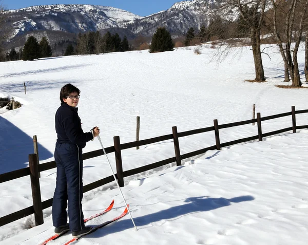 Paisaje de los Alpes italianos con niño solitario con esquís de fondo —  Fotos de Stock