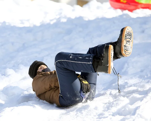 Niño disfrutando de trineo en la nieve en las montañas en invierno —  Fotos de Stock