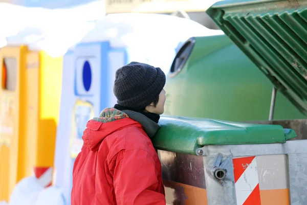 Pobre chico intenta comer en la caja de residuos — Foto de Stock