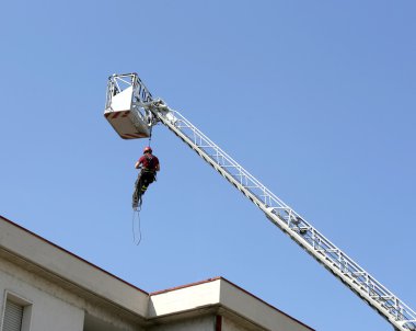 binanın içinde iple aşağı itfaiyeci