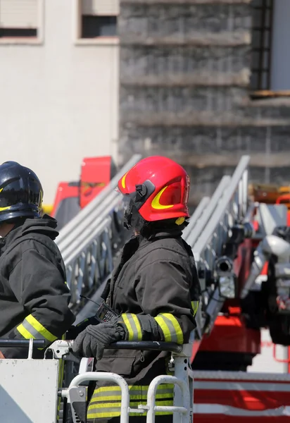 Firefighter in the cage of fire engine — Stock Photo, Image