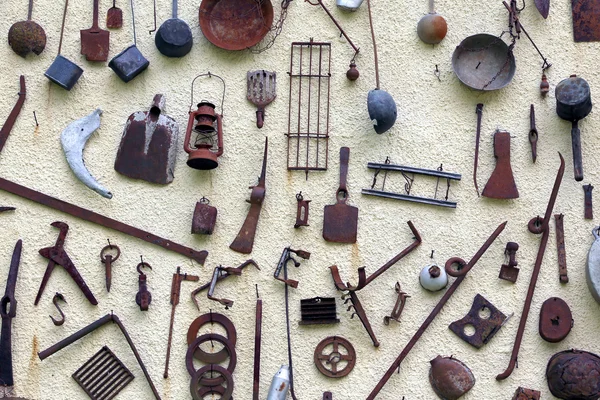 Многие древние сельскохозяйственные инструменты, висящие на стене сельского Хоуса — стоковое фото