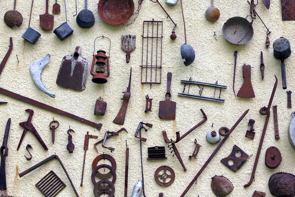 many ancient farming tools hanging on the wall of the rural Hous