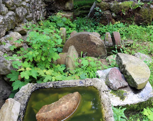 Old stone wheel of abandoned water mill to grind flour — Stok fotoğraf