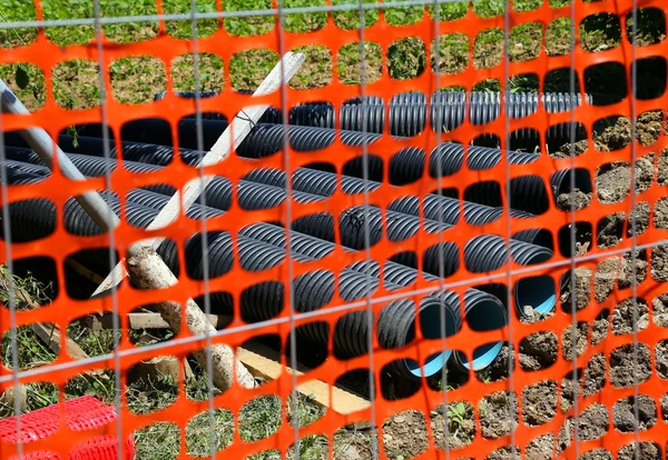 Estrada quintal com tubos grandes para cabos de fibra óptica durante a escavação — Fotografia de Stock