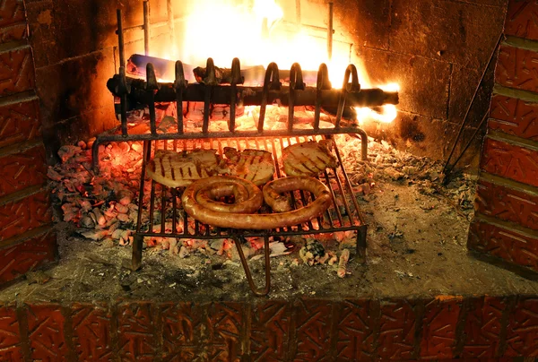 Viande savoureuse avec saucisse et hacher dans la cheminée avec le ember — Photo