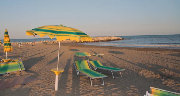 Ombrelloni sulla spiaggia in riva al mare in estate — Foto Stock