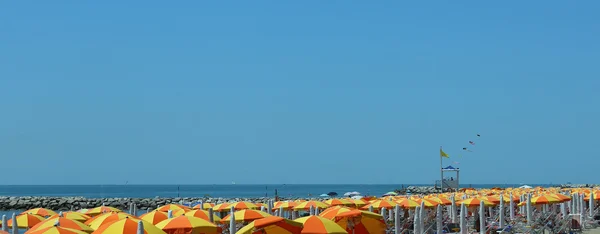 Muchas sombrillas de colores en la playa junto al mar —  Fotos de Stock