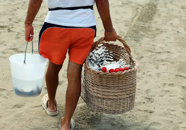 Verkoper op het strand met Fruitspiesjes gemaakt met kokos — Stockfoto