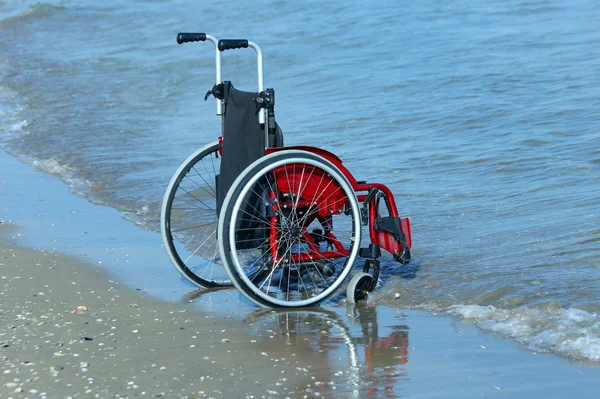 Yaz aylarında kumlu plajında deniz kıyısında tekerlekli sandalye — Stok fotoğraf