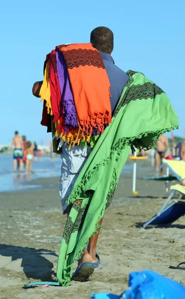 Vendedor africano de telas y fundas en la playa en verano —  Fotos de Stock