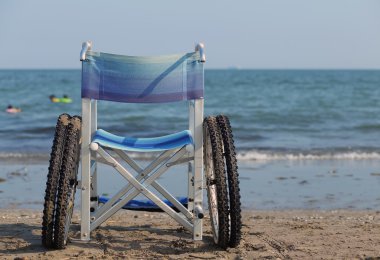 plajın kumları üzerinde hareket etmek için tekerlekli sandalye