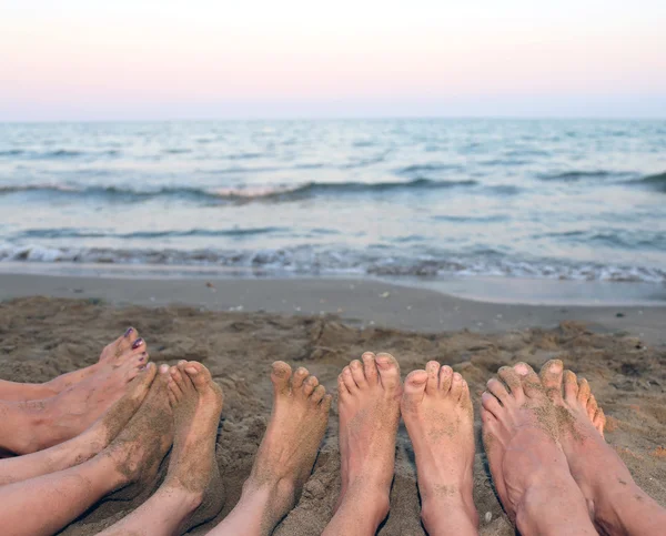 Voeten van een gezin blote voeten door de zee op het strand in de zomer — Stockfoto