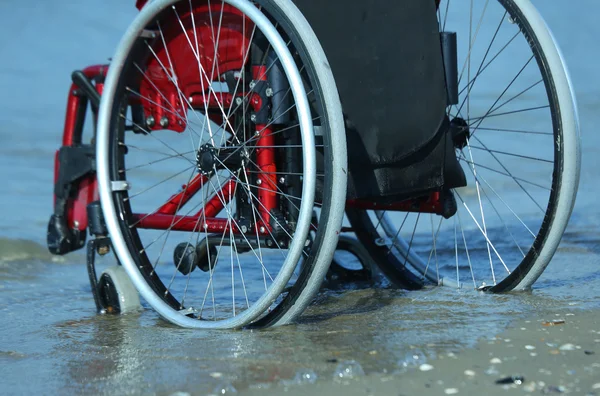 Cadeira de rodas presa na areia — Fotografia de Stock