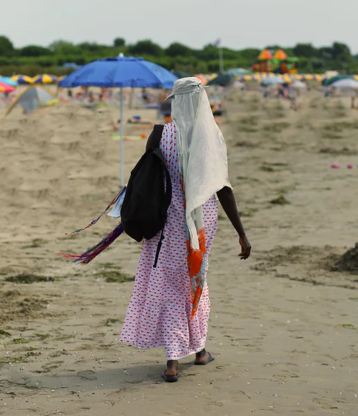 Mujer africana Peina el cabello con trenzas de colores en la playa en su —  Fotos de Stock