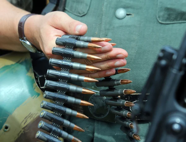 Soldado de uniforme com balas na mão pronto para atirar — Fotografia de Stock