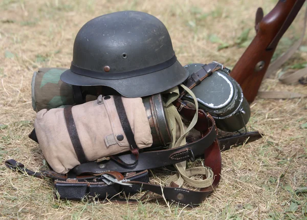 Capacete com um rifle no acampamento do exército durante um exercício de guerra — Fotografia de Stock