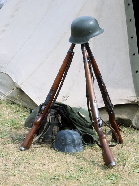 Tre gamla kriget gevär och hjälmar av död soldat i krig — Stockfoto