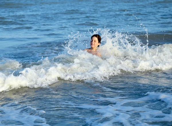 Bambino SPLASHING tra le onde del mare in estate — Foto Stock