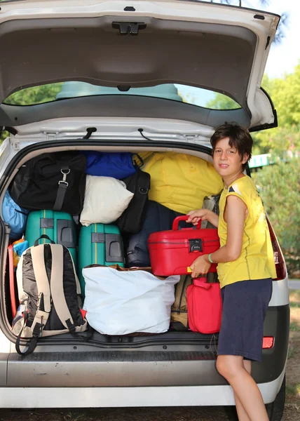 Bambino carichi borse nel bagagliaio in estate — Foto Stock