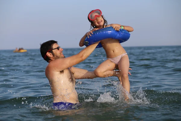 Padre gioca con la figlia in mare durante l'estate holi — Foto Stock